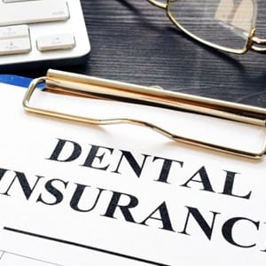 dental insurance form on a blue clipboard