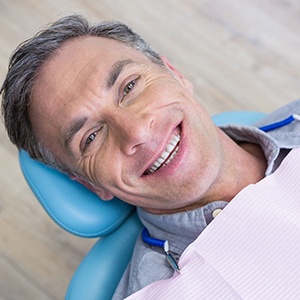 Man smiling in dental chair while laying back