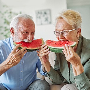 A man and woman eating watermelon