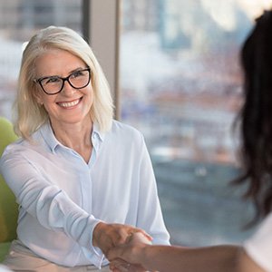 A woman shaking hands at a business meeting