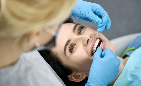 flossing patient’s teeth during dental exam in Oklahoma City