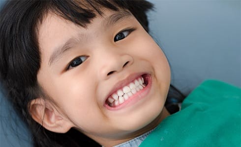 Child smiling after fluoride treatment