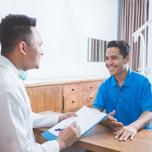 patient and dentist talking and smiling 