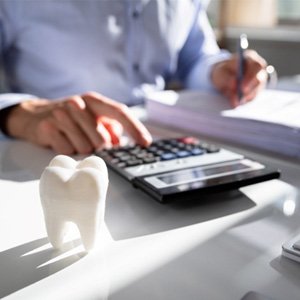 tooth with someone working on a calculator   