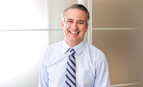 older man in dress shirt and tie smiling with dental crowns in Oklahoma City