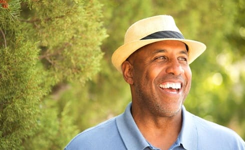 older man in blue polo smiling with dentures in Oklahoma City