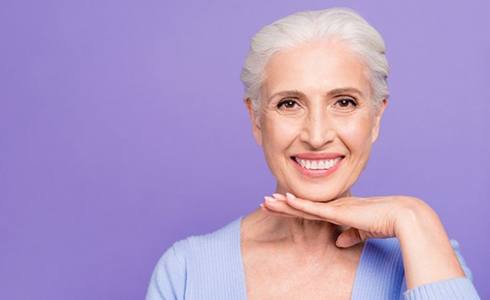 Woman smiles after hearing denture FAQs in Oklahoma City