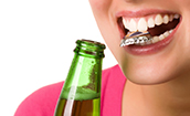Woman in danger of a chipped cracked tooth in Oklahoma City chewing on bottle cap