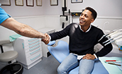 Patient shaking the hand of his Oklahoma City emergency dentist