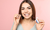 Young woman flossing to prevent dental emergencies in Oklahoma City