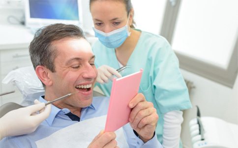 man smiling in dental mirror   