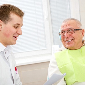 An older man listening to his dentist in Oklahoma City discuss dental implants