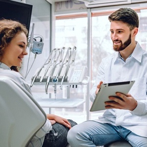 implant dentist in Oklahoma City showing a patient information on a tablet