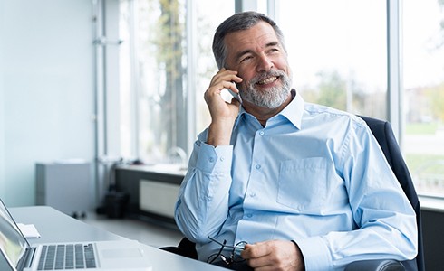 businessman sitting at a desk and talking on the phone 