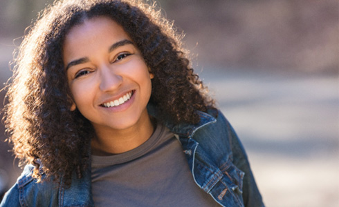 Teen girl in jean jacket smiling
