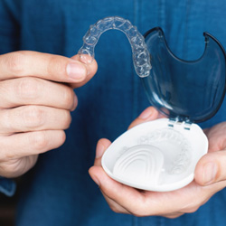 Closeup of patient holding clear aligner