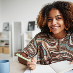 Teen girl smiling while working on homework