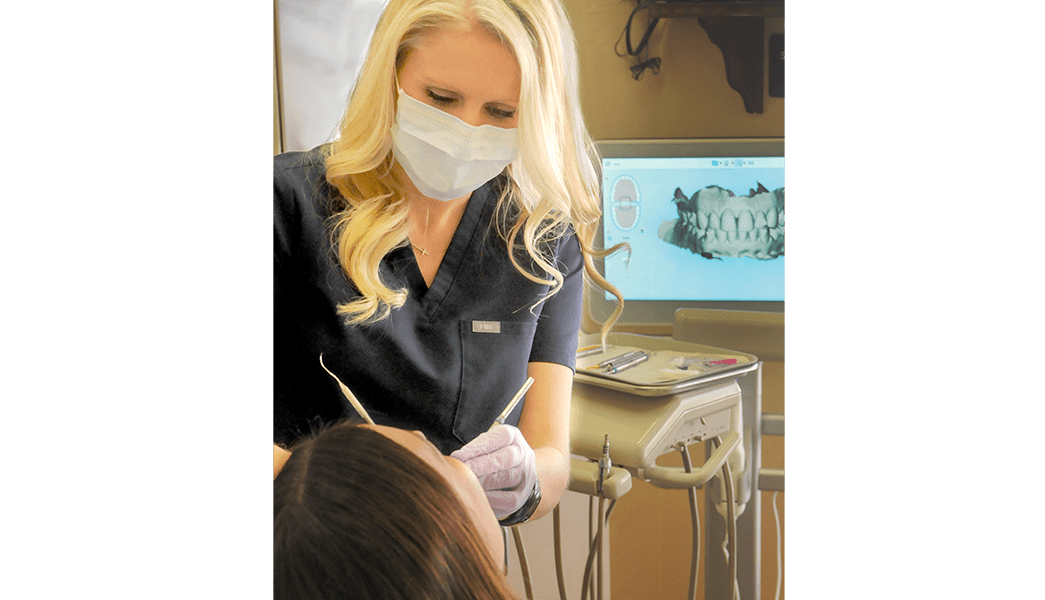 Dental hygienist cleaning patient's teeth