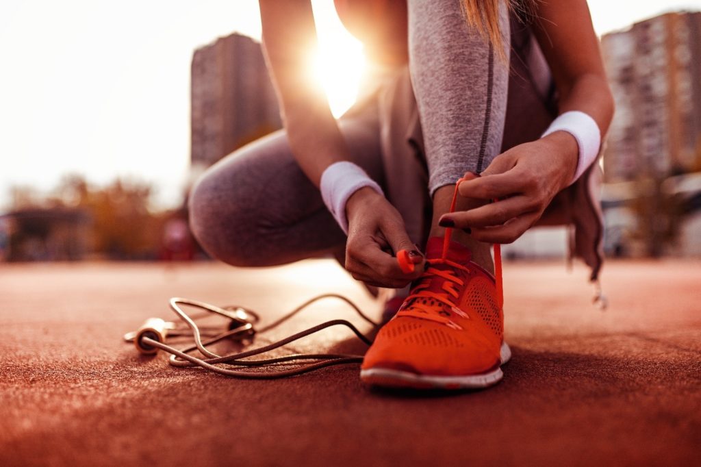 Woman tying her running shoes before exercising.