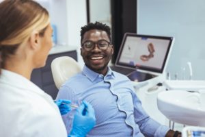 a man smiling at a dental checkup and ready to ask his dentist questions