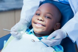 a child smiling after receiving pulp therapy to save one of his teeth