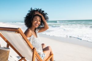 a woman smiling with healthy teeth during the summer